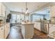 Open-concept kitchen with white cabinets, granite countertops, a central island, and hardwood floors at 8709 Barrelli Ct, Charlotte, NC 28277