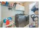Efficient laundry room with a gray washer and dryer, storage cabinets, and natural light at 8709 Barrelli Ct, Charlotte, NC 28277