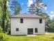 Rear exterior of home features sliding glass doors, neutral siding, dark-framed windows, and a well-manicured lawn at 8717 Lawyers Rd, Charlotte, NC 28227