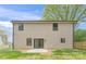 Backyard view of home with tan siding, black trim, sliding glass door and patio at 8717 Lawyers Rd, Charlotte, NC 28227