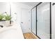 Bathroom featuring double sinks, black fixtures, a marble shower and white cabinets at 8717 Lawyers Rd, Charlotte, NC 28227