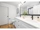 Bathroom featuring double sinks, black fixtures, white marble wall accents, and white cabinets at 8717 Lawyers Rd, Charlotte, NC 28227