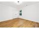 Empty bedroom features a double door closet, window, and hardwood floors at 8717 Lawyers Rd, Charlotte, NC 28227
