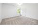 Bright bedroom featuring plush carpet, a double door closet, and natural light from a window at 8717 Lawyers Rd, Charlotte, NC 28227