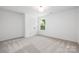 Bright bedroom featuring plush carpet, a double door closet, and natural light from a window at 8717 Lawyers Rd, Charlotte, NC 28227
