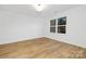 Well-lit bedroom featuring wood-look floors, a window, and neutral decor at 8717 Lawyers Rd, Charlotte, NC 28227