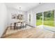 Bright dining room features wood floors, modern chandelier and sliding glass door to the backyard at 8717 Lawyers Rd, Charlotte, NC 28227