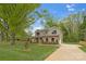Well-manicured lawn and front yard leads to a two-story home with brick and siding, and a concrete driveway at 8717 Lawyers Rd, Charlotte, NC 28227