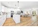 Modern kitchen with white cabinetry, stainless steel appliances, hardwood floors, and island seating at 8717 Lawyers Rd, Charlotte, NC 28227