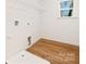 Bright laundry room features wire shelving and wood-look floors for a clean, modern look at 8717 Lawyers Rd, Charlotte, NC 28227