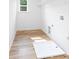 Bright laundry room featuring wood-look flooring and a utility sink at 8717 Lawyers Rd, Charlotte, NC 28227