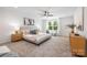 Main bedroom features a ceiling fan, neutral carpet, and a bright window at 8717 Lawyers Rd, Charlotte, NC 28227