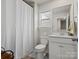 Cozy bathroom featuring a shower with curtain, toilet, sink and window with natural light at 1005 Cheviot Ct, Waxhaw, NC 28173