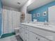 Bright bathroom featuring double sink vanity, large mirror, colorful shower curtain, and modern fixtures at 1005 Cheviot Ct, Waxhaw, NC 28173