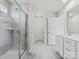 Bright bathroom features a glass shower door, marble-look tile, and a white vanity with a single sink at 1005 Cheviot Ct, Waxhaw, NC 28173