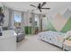 A cheerful bedroom featuring a dinosaur themed bed and mountain wall decor, with natural light from two windows at 1005 Cheviot Ct, Waxhaw, NC 28173
