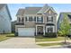 Charming two-story home features a two-car garage, manicured lawn, and an inviting front porch at 1005 Cheviot Ct, Waxhaw, NC 28173