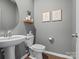 Stylish half bathroom features modern fixtures, a round mirror, and decorative wall art at 1005 Cheviot Ct, Waxhaw, NC 28173
