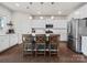 Modern kitchen features white cabinets, stainless steel appliances, island with pendant lighting and seating at 1005 Cheviot Ct, Waxhaw, NC 28173