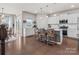 Spacious kitchen featuring white cabinets, stainless steel appliances, island with seating, and hardwood floors at 1005 Cheviot Ct, Waxhaw, NC 28173