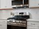 Stainless steel range in modern kitchen with white cabinets and subway tile backsplash at 1005 Cheviot Ct, Waxhaw, NC 28173
