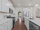 Modern kitchen with white cabinets, stainless steel appliances, and hardwood flooring at 1005 Cheviot Ct, Waxhaw, NC 28173