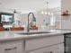 Close-up of kitchen island with stainless steel sink and view of living area at 1005 Cheviot Ct, Waxhaw, NC 28173