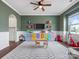 Spacious playroom with white wainscoting, a ceiling fan, and hardwood floors at 1005 Cheviot Ct, Waxhaw, NC 28173