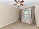 Cozy bedroom features a ceiling fan, neutral walls, and a large window with stylish curtains at 10727 Ryan Courtney Sq, Mint Hill, NC 28227