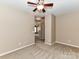 A bedroom with neutral carpet and walls, a ceiling fan and a view of the hallway at 10727 Ryan Courtney Sq, Mint Hill, NC 28227