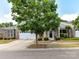 Charming brick home with a two-car garage, a manicured lawn, and a lovely shade tree in the front yard at 10727 Ryan Courtney Sq, Mint Hill, NC 28227