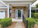 Inviting covered front porch with brick facade, white columns, and manicured greenery at 10727 Ryan Courtney Sq, Mint Hill, NC 28227