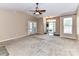 Bright and airy living room with neutral carpet, ceiling fan, and view of the entry at 10727 Ryan Courtney Sq, Mint Hill, NC 28227