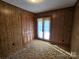 Bedroom showcasing wood paneling, closet doors, and neutral-toned carpet at 1074 25Th Ne St, Hickory, NC 28601