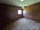 Bedroom featuring wood paneling, neutral-toned carpet, and natural light from one window at 1074 25Th Ne St, Hickory, NC 28601