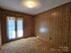Bedroom showcasing natural light, wood paneling, and neutral-toned carpet at 1074 25Th Ne St, Hickory, NC 28601