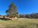 Large grassy yard with mature trees surrounding a brick home at 1074 25Th Ne St, Hickory, NC 28601