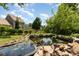Backyard pond with water lilies is framed by rocks and mature landscaping at 109 Arabian Ln, Salisbury, NC 28147
