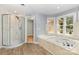 Inviting bathroom with a soaking tub, glass shower, and wood-look tile flooring for a spa-like experience at 109 Arabian Ln, Salisbury, NC 28147