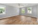 Spacious bedroom with hardwood floors, neutral walls, and natural light streaming through three windows at 109 Arabian Ln, Salisbury, NC 28147