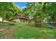 Expansive backyard featuring a wooden deck, mature trees, lush grass, and playset at 110 Lakeland Rd # 19, Mooresville, NC 28117