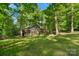 A well-maintained lawn surrounds a single story house with a wooden deck among mature shade trees at 110 Lakeland Rd # 19, Mooresville, NC 28117