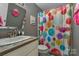 Colorful bathroom with bright shower curtain, playful decor, and a large mirror at 110 Lakeland Rd # 19, Mooresville, NC 28117
