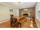Cozy dining room with a stone fireplace, hardwood floors, and an elegant table and bench at 110 Lakeland Rd # 19, Mooresville, NC 28117