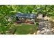 Landscaped yard featuring a single story home with a wooden deck, nestled amongst lush greenery and mature trees at 110 Lakeland Rd # 19, Mooresville, NC 28117