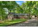 Charming single story home featuring a wooden deck, stone accents, and beautifully landscaped front yard with mature trees at 110 Lakeland Rd # 19, Mooresville, NC 28117