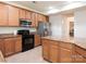 Attractive kitchen showcasing wood cabinets, black appliances, and granite countertops at 12304 Lookout Point Dr, Charlotte, NC 28269