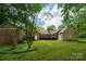Spacious backyard with a deck, lush greenery, and mature trees at 1260 Piccadilly Dr, Charlotte, NC 28211
