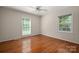 Empty bedroom featuring beautiful hardwood floors, two windows, and a ceiling fan at 1260 Piccadilly Dr, Charlotte, NC 28211