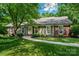 Charming single Gathering home featuring a well-manicured lawn, brick accents, and an inviting walkway to the front door at 1260 Piccadilly Dr, Charlotte, NC 28211